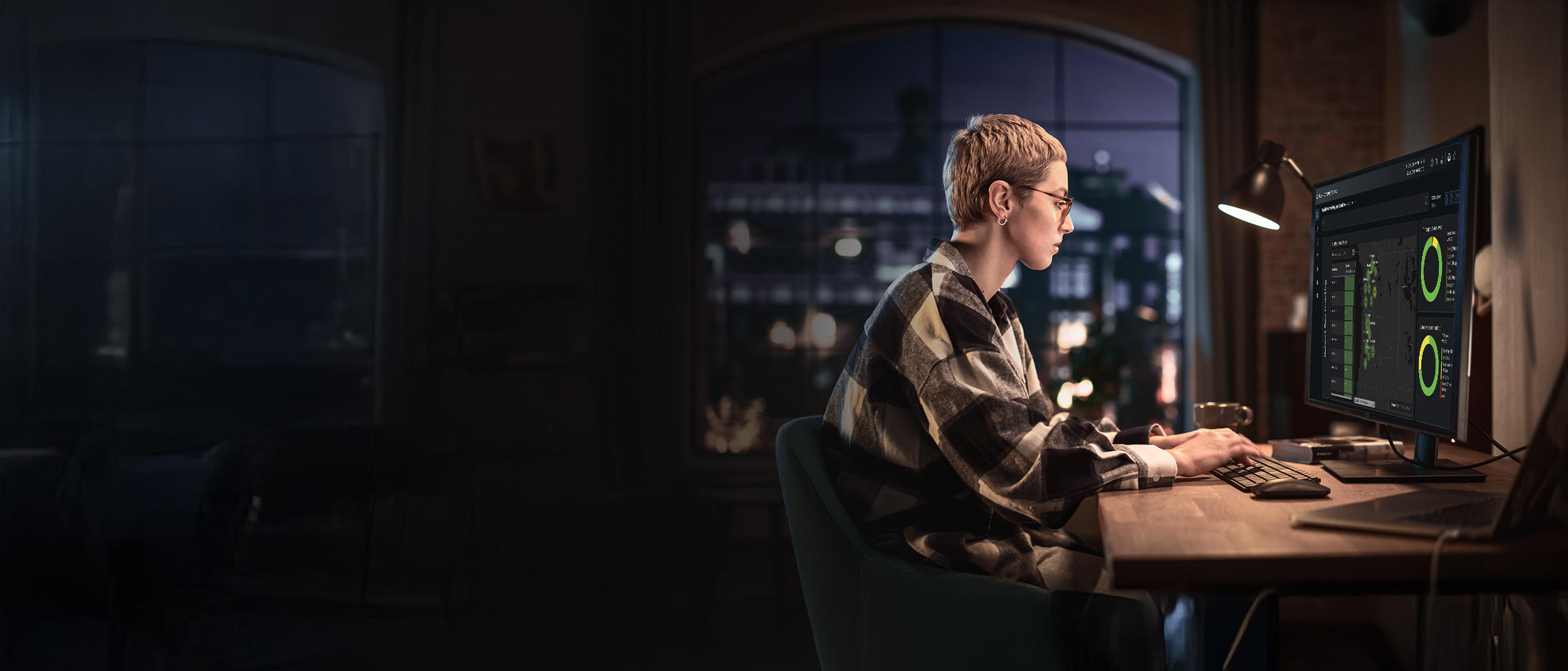 IT professional analyzing a network traffic dashboard with data visualization charts on a computer monitor