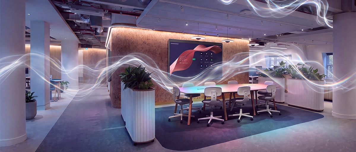Modern conference room with a large screen and meeting table, stylized with glowing light waves.