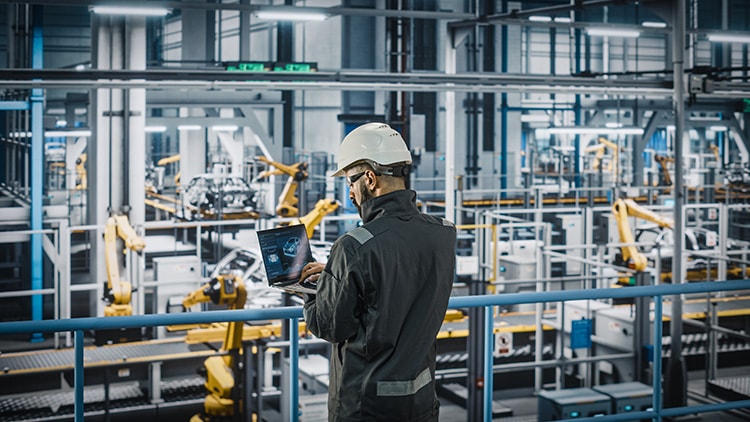 Factory worker examines factory floor data