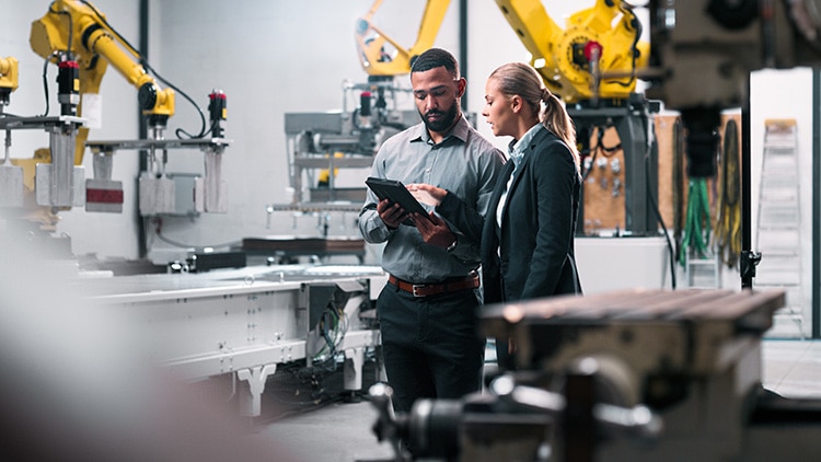 Factory workers collaborate on a device